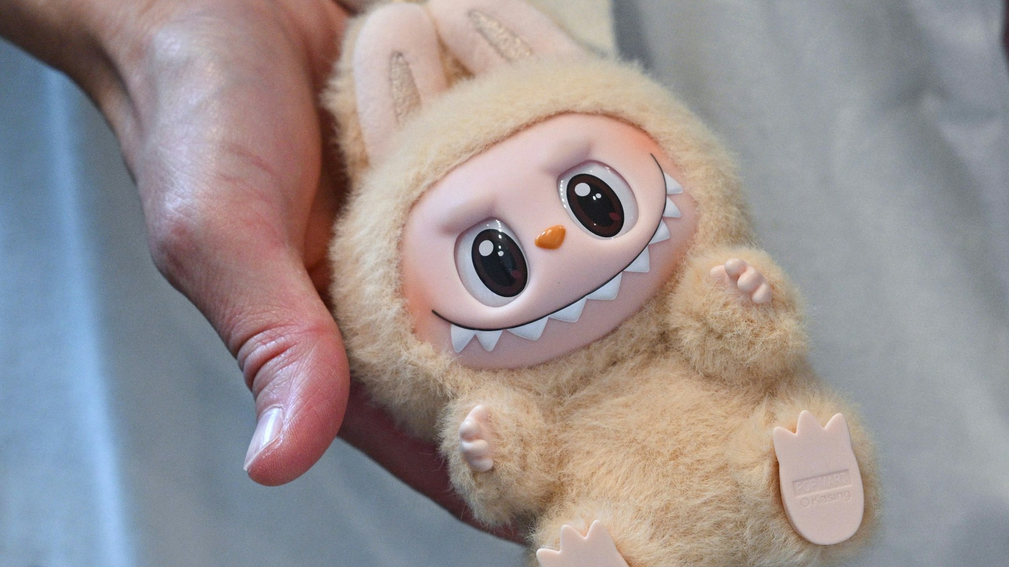 Eine Frau hält eine Labubu-Plüschfigur bei der Eröffnung des ersten Labubu-Store Deutschlands im Alexa Einkaufscenter in der Hand.