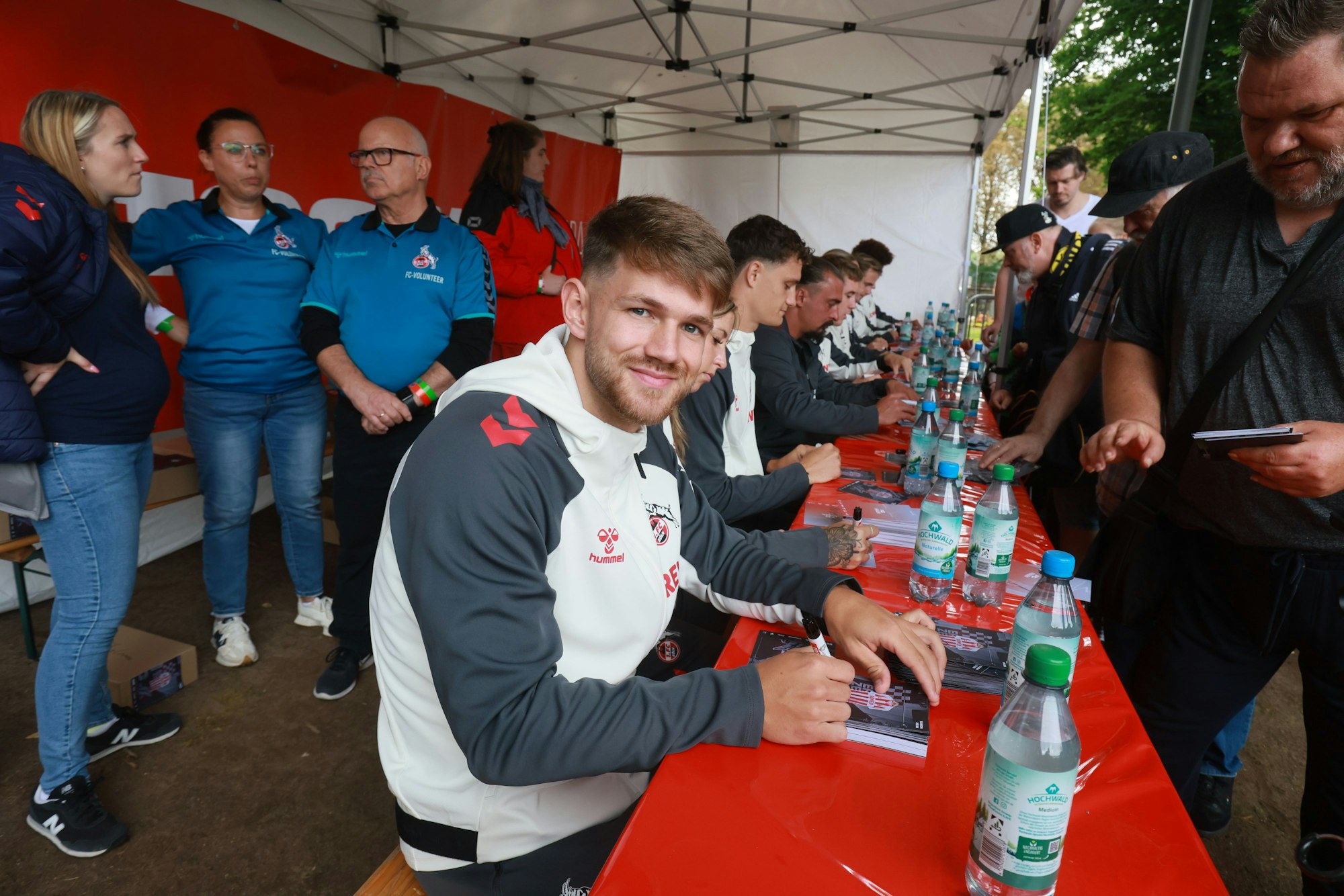 Jan Thielmann schreibt bei der Saisoneröffnung des 1. FC Köln Autogramme.