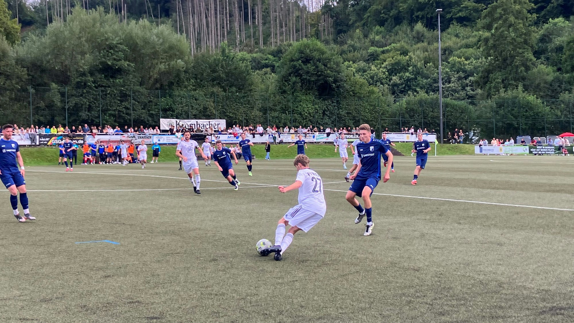 Eine Spielsituation zwischen zwei Teams sauf einem Fußballplatz.