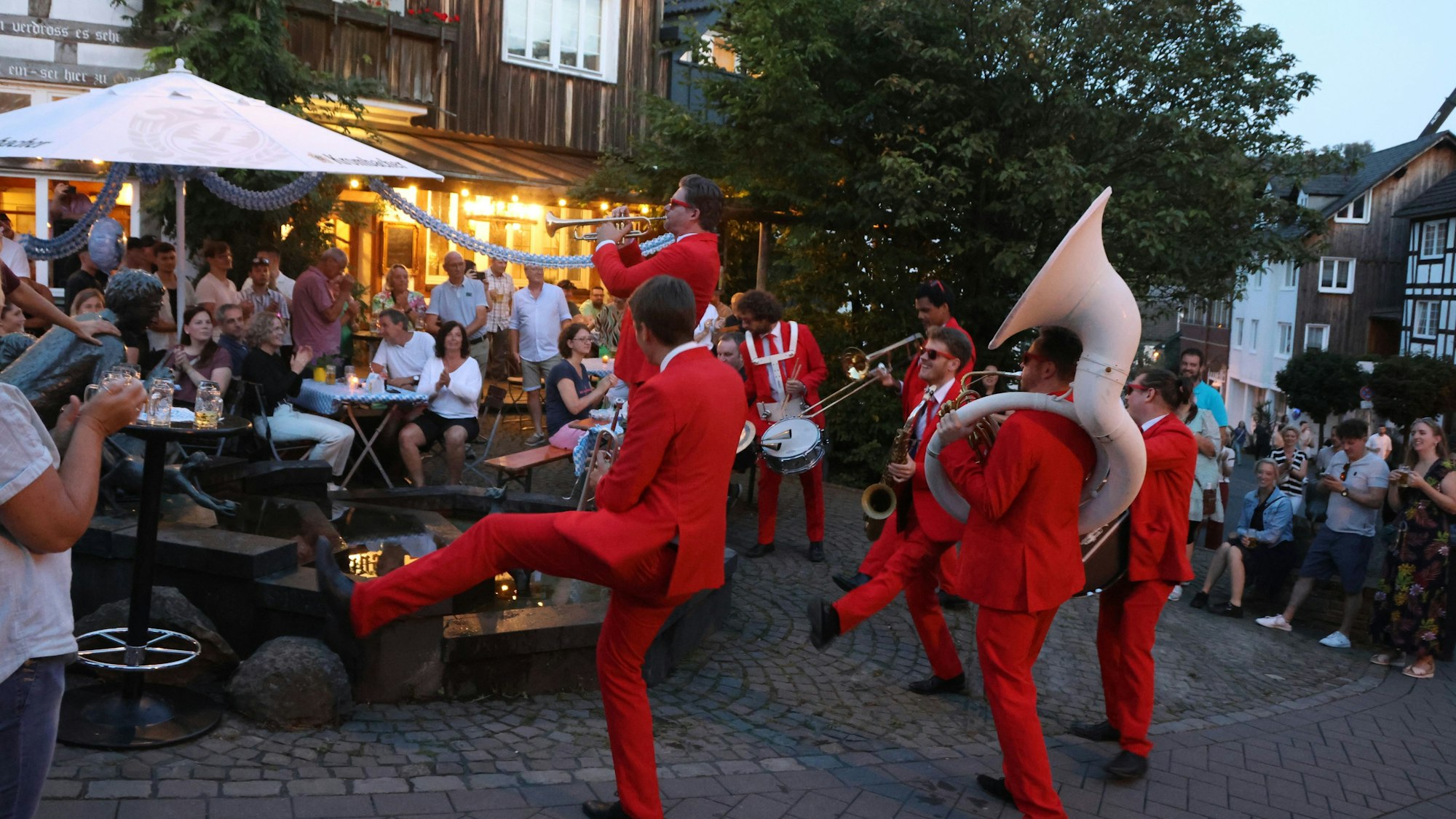Musiker spielen vor einem Gatshaus.