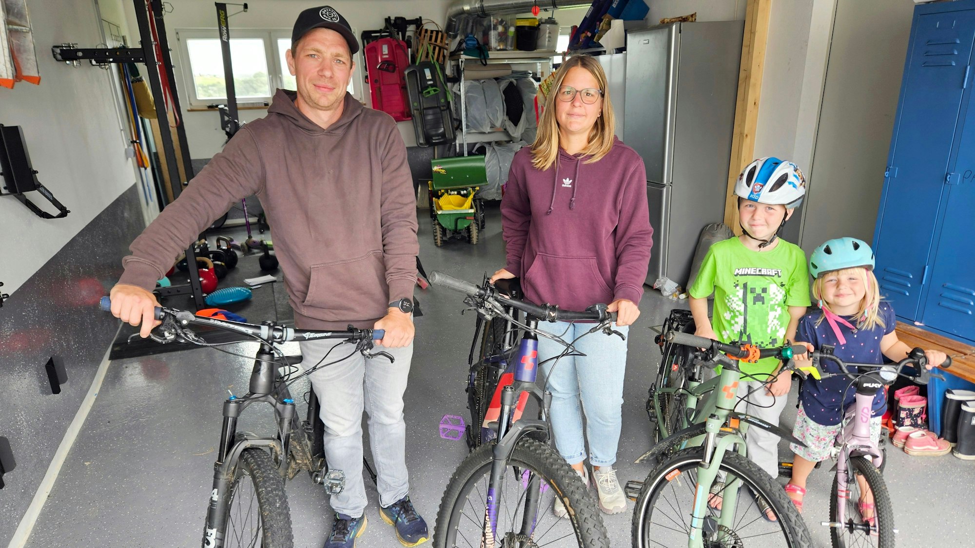Lukas, Sabrina, Jakob und Paula Herr stehen nebeneinander mit ihren Fahrrädern in einer Garage.