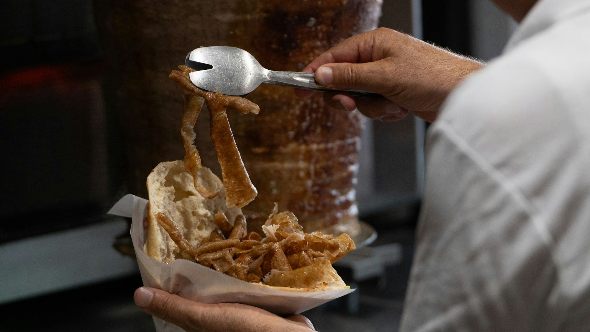 Vom Spieß ins Brot: Ein Mann bereitet einen Döner zu. (Archivbild)