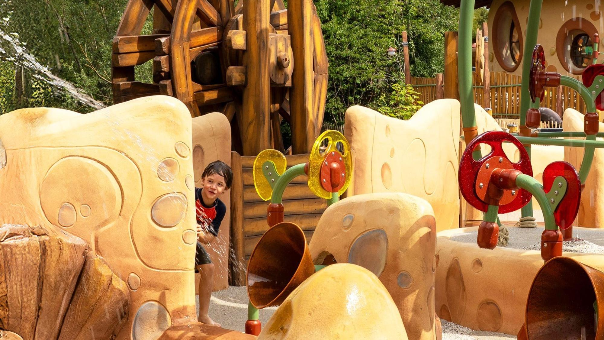 Das Bild zeigt einen Wasserparcours und einen kleinen Jungen, der sich versteckt hat.