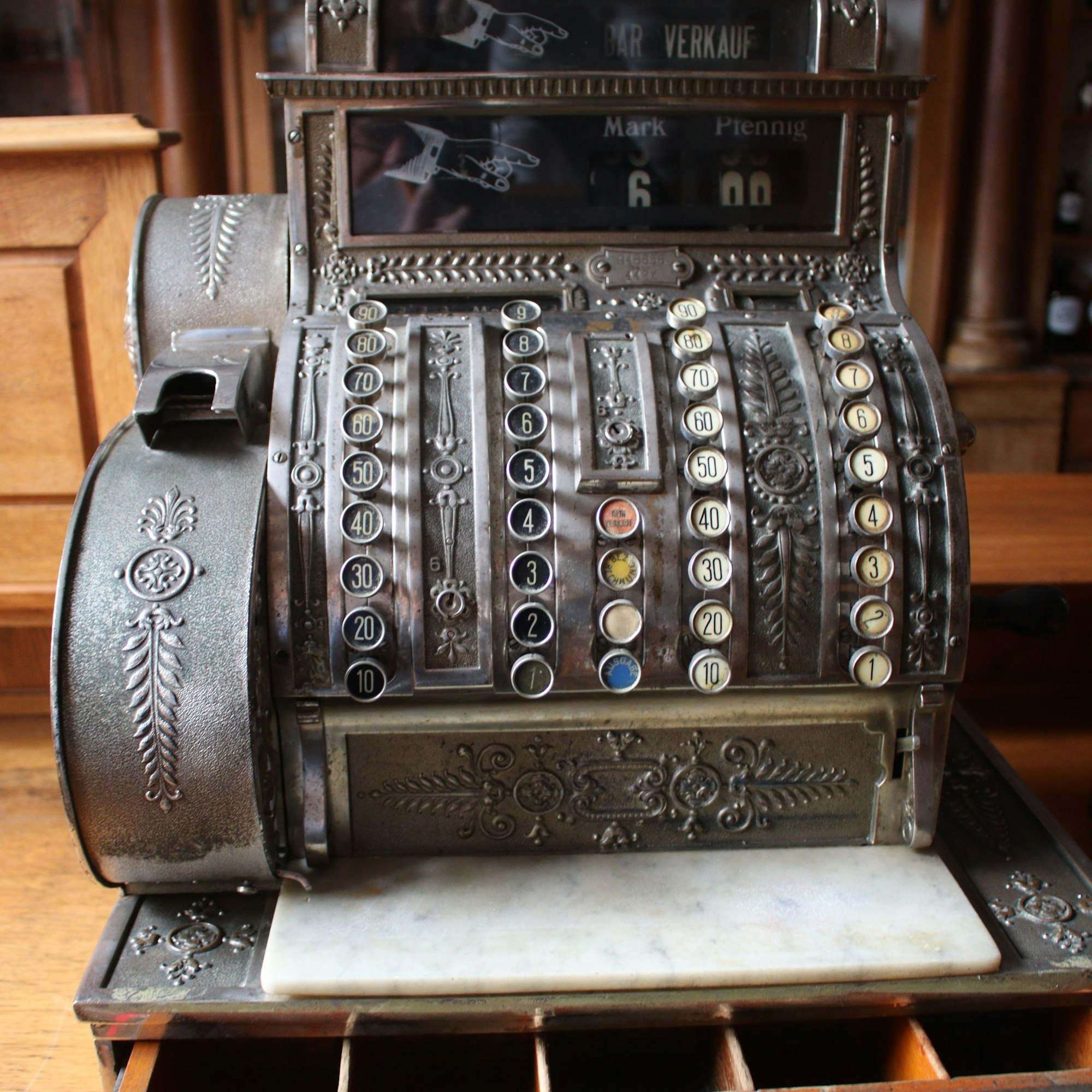 Eine geöffnete alte Kasse, auf der die Verkaufssumme von 6,00 Mark abgebildet ist.