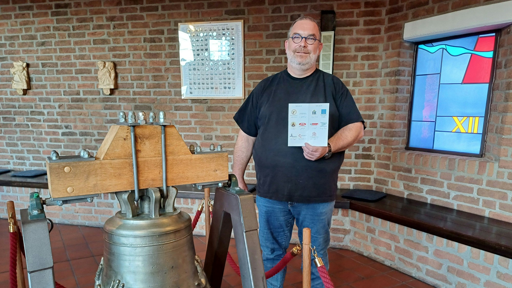 Diakon Michael Oschmann steht neben der Friedensglocke.