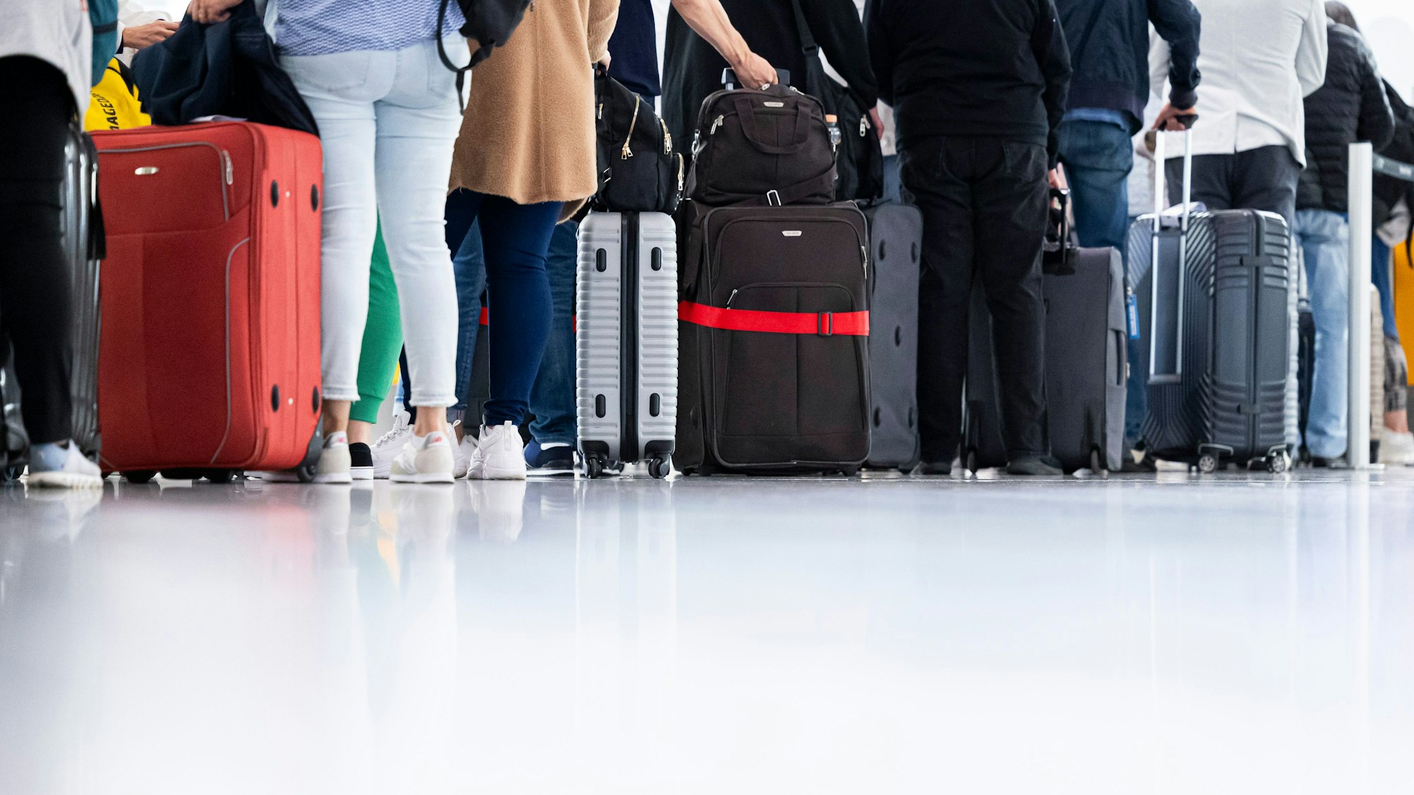 Fluggäste warten am Morgen im Flughafen Hannover-Langenhagen. Michael Matthey/dpa