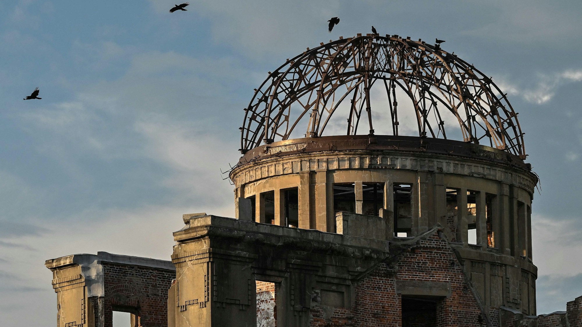 Crows fly around the top of the Atomic Bomb Dome on the eve of the 80th anniversary of the world's first atomic bomb attack, in the city of Hiroshima on August 5, 2025. (Photo by Richard A. Brooks / AFP)