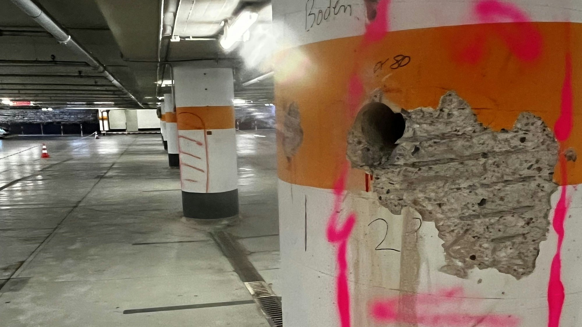 Bohrlöcher und großflächige Markierungen auf den Säulen in der Tiefgarage unter dem Dom, in der viele Parkplätze gesperrt sind.