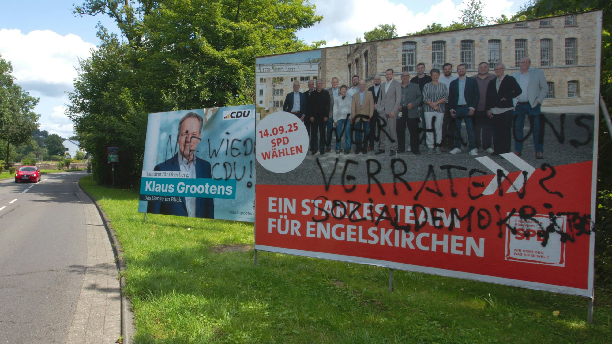 Mit schwarzer Sprühfarbe haben Unbekannte diese Wahlkampf-Plakate von CDU und SPD in Engelskirchen verunstaltet.