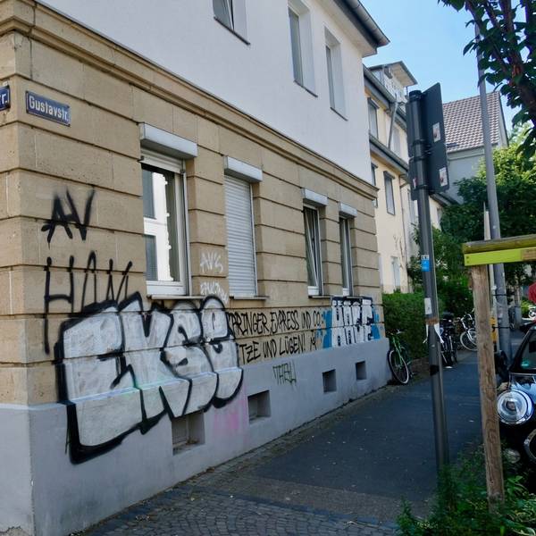 Eine Häuserecke ist mit großen Buchstaben besprüht.