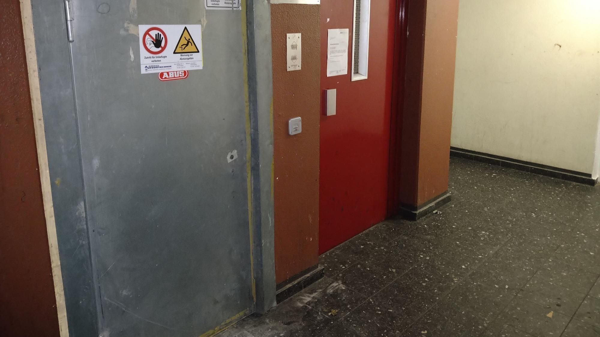 Zwei Aufzugtüren in einem schmucklosen Treppenhaus sind zu sehen.