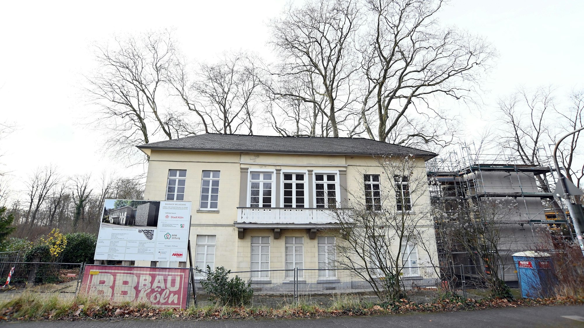 Ein frei stehendes herrschaftlich aussehendes Gebäude ist teilweise mit Gerüsten versehen.