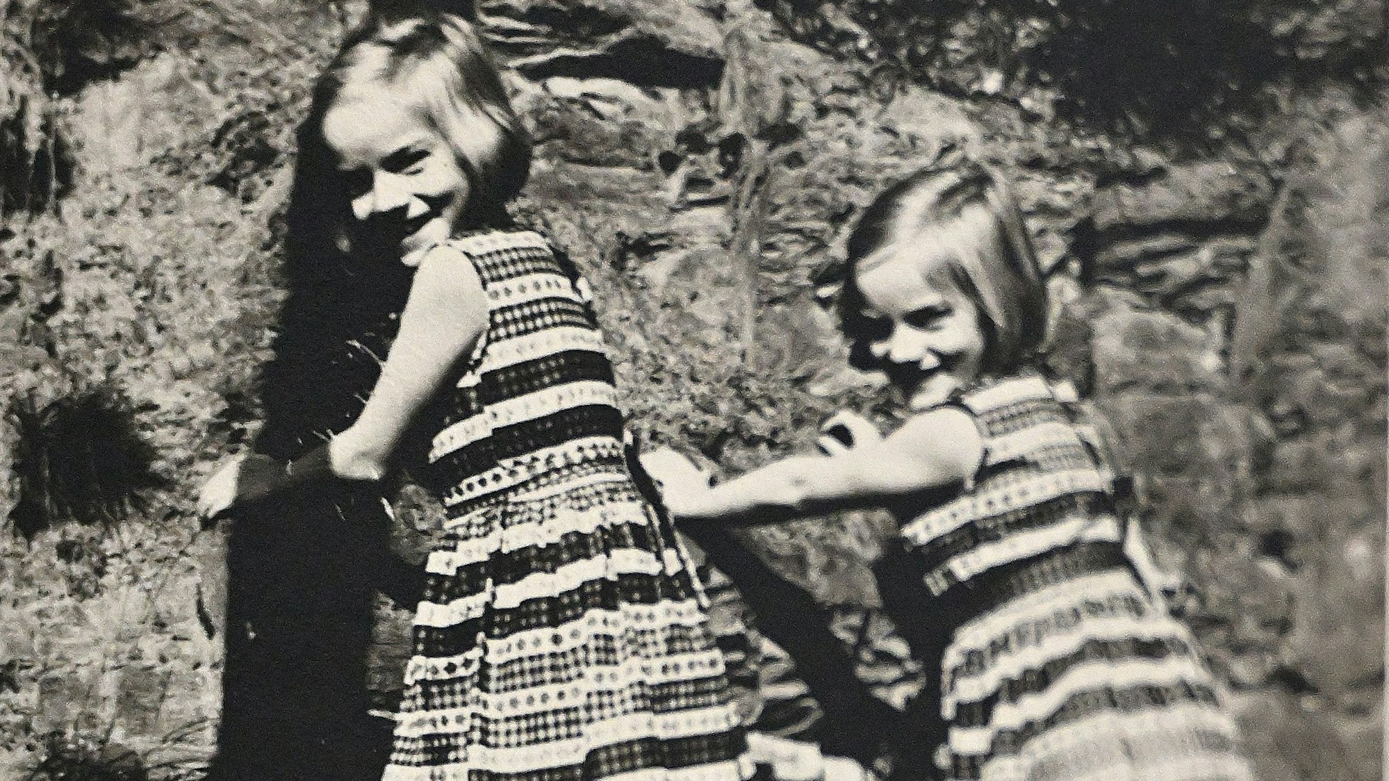 Kinderfoto der Zwillinge an einem Hügel.