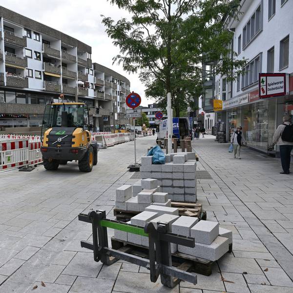 Ein Baufahrzeug fährt auf einem neu gepflasterten Straßenstück.