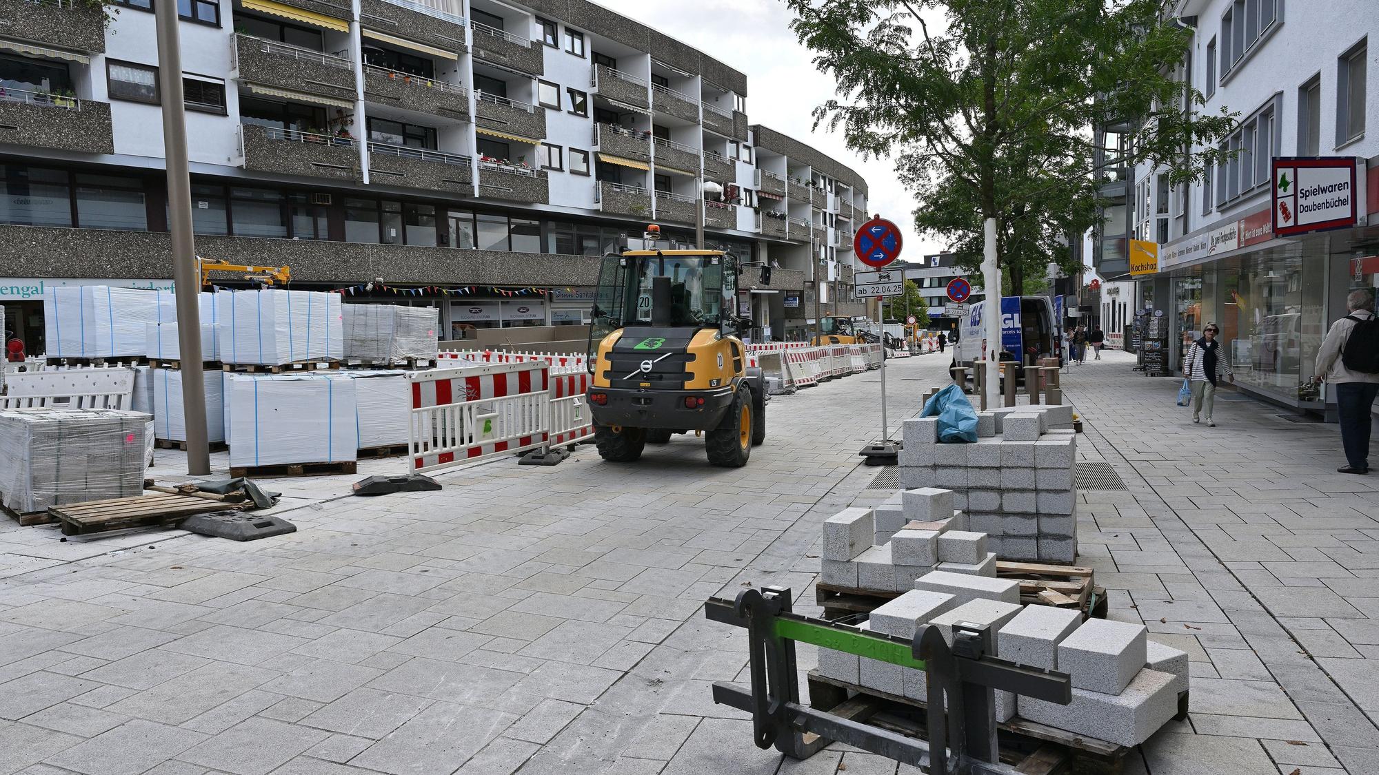 Ein Baufahrzeug fährt auf einem neu gepflasterten Straßenstück.