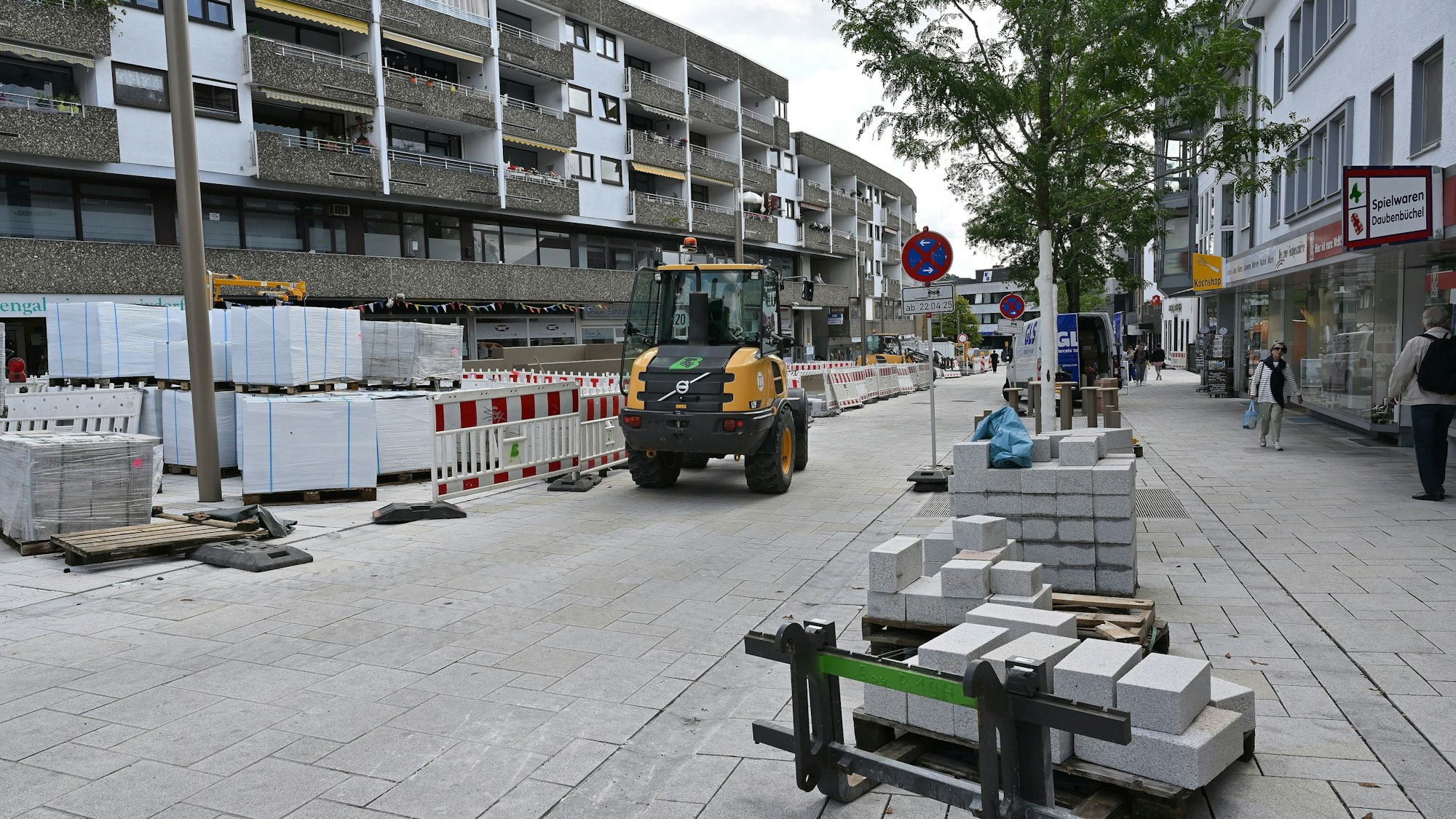 Ein Baufahrzeug fährt auf einem neu gepflasterten Straßenstück.