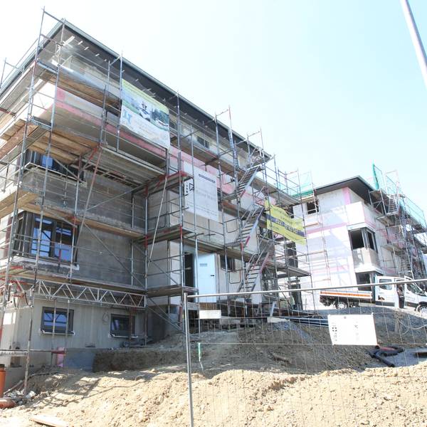Ein Haus in Much wird gebaut und ist von allen Seiten von einem Gerüst umschlossen.
