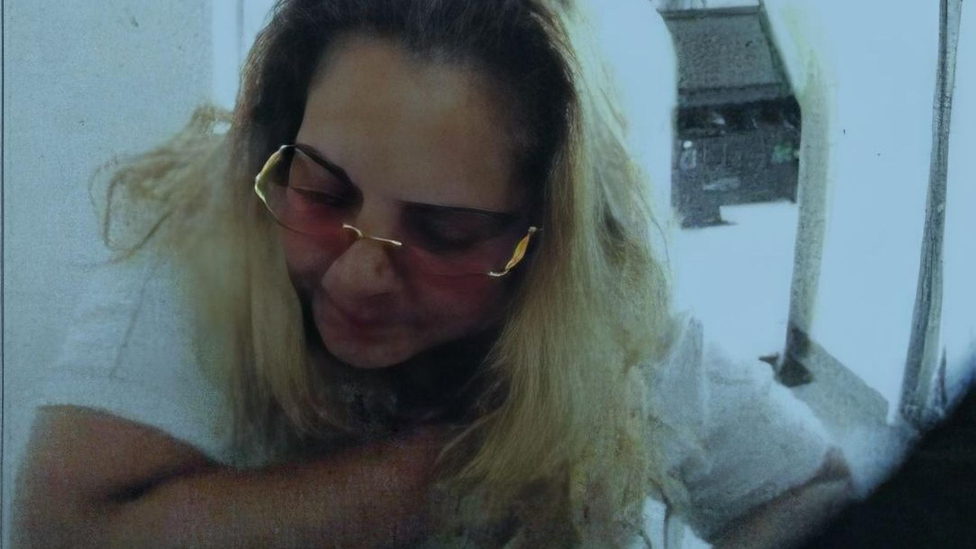 Das Fahndungsfoto zeigt eine Frau mit blonden Haaren und Brille.