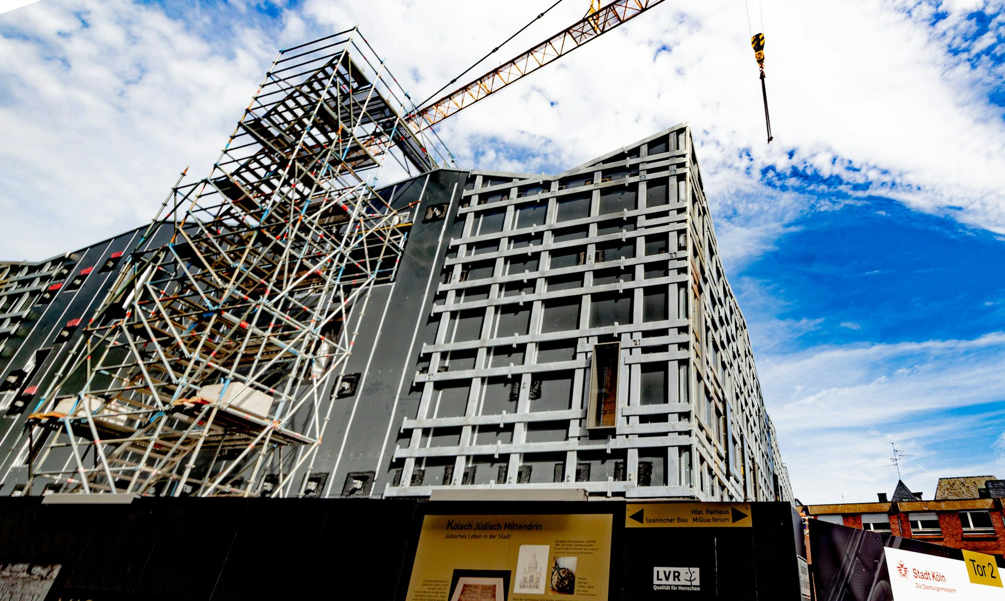 Ein Baugerüst steht an der unfertigen MiQua-Fassade.