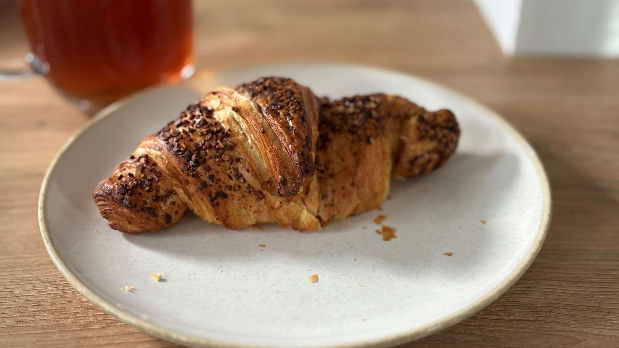 Auf einem Teller liegt ein Croissant.