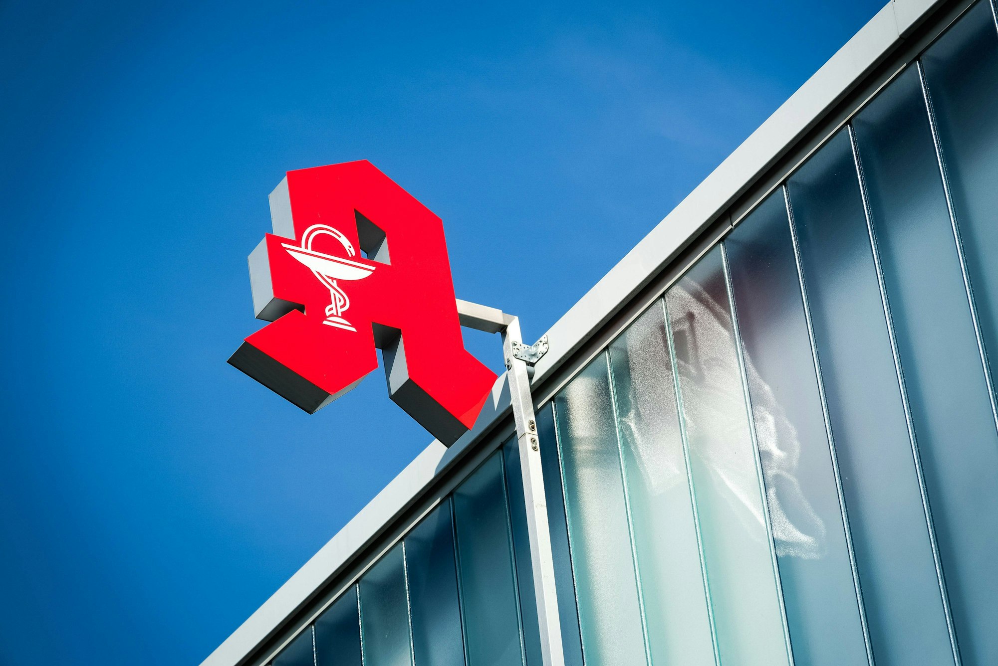 Ein Apothekenschild an einer Hausfassade.