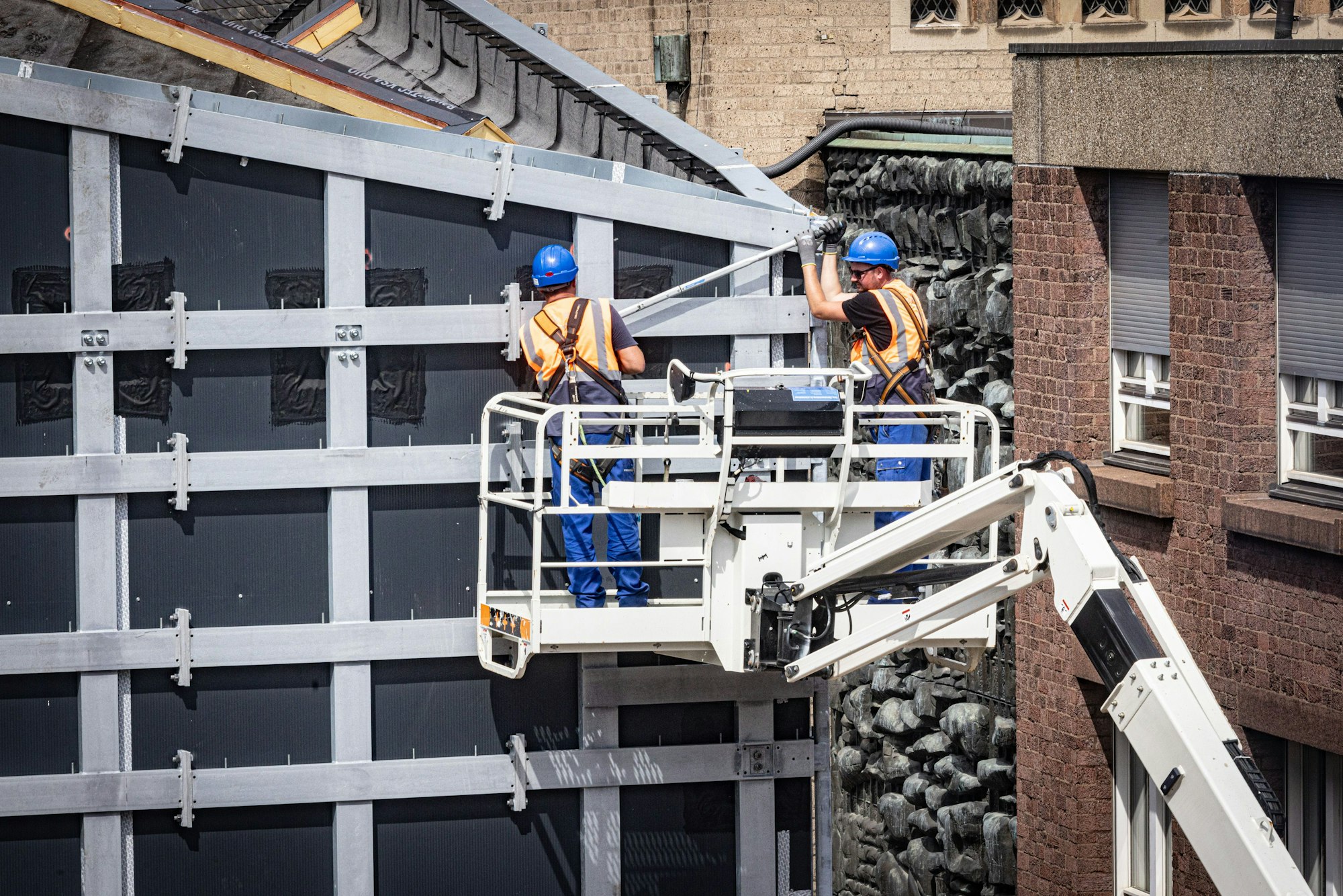 Handwerker arbeiten an der Fassade des MiQua.