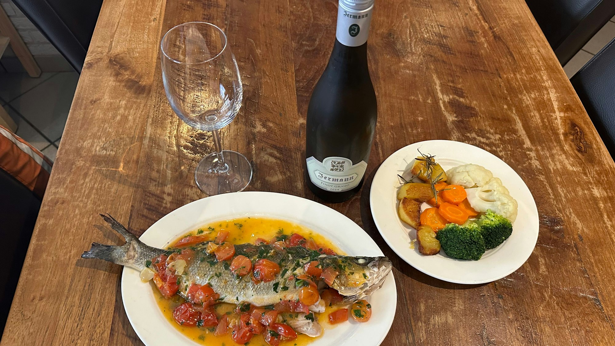 Ein Wolfsbarsch aus dem Holzofen mit frischem Gemüse der Saison.