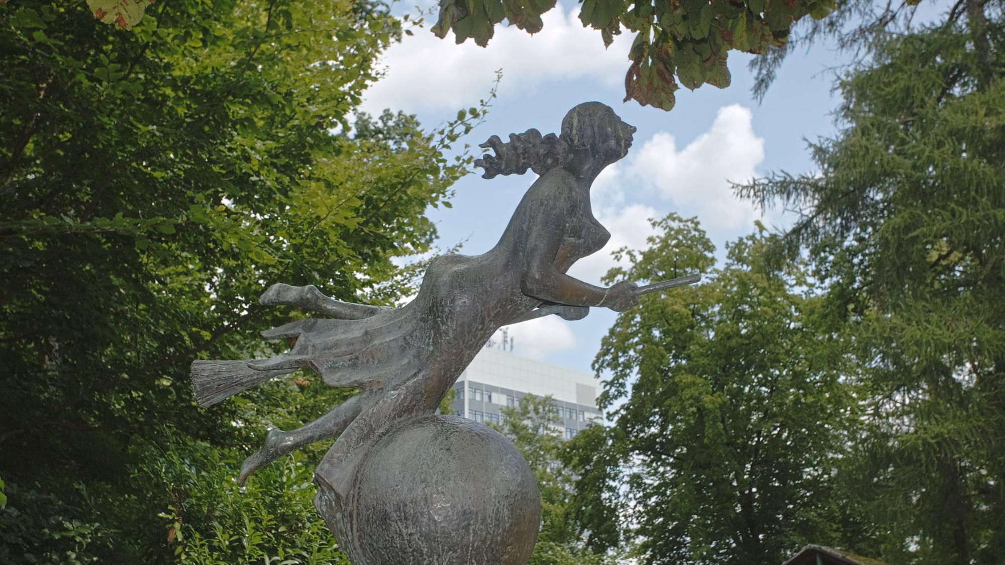 Eine Hexenstatue in einem Park.