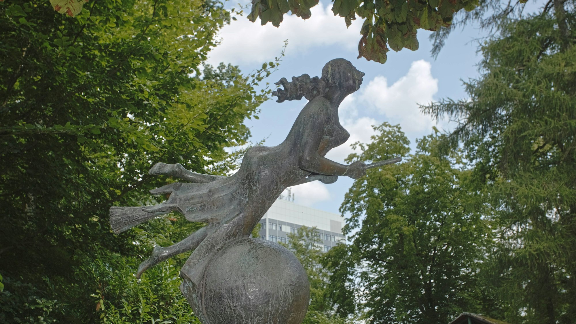 Eine Hexenstatue in einem Park.