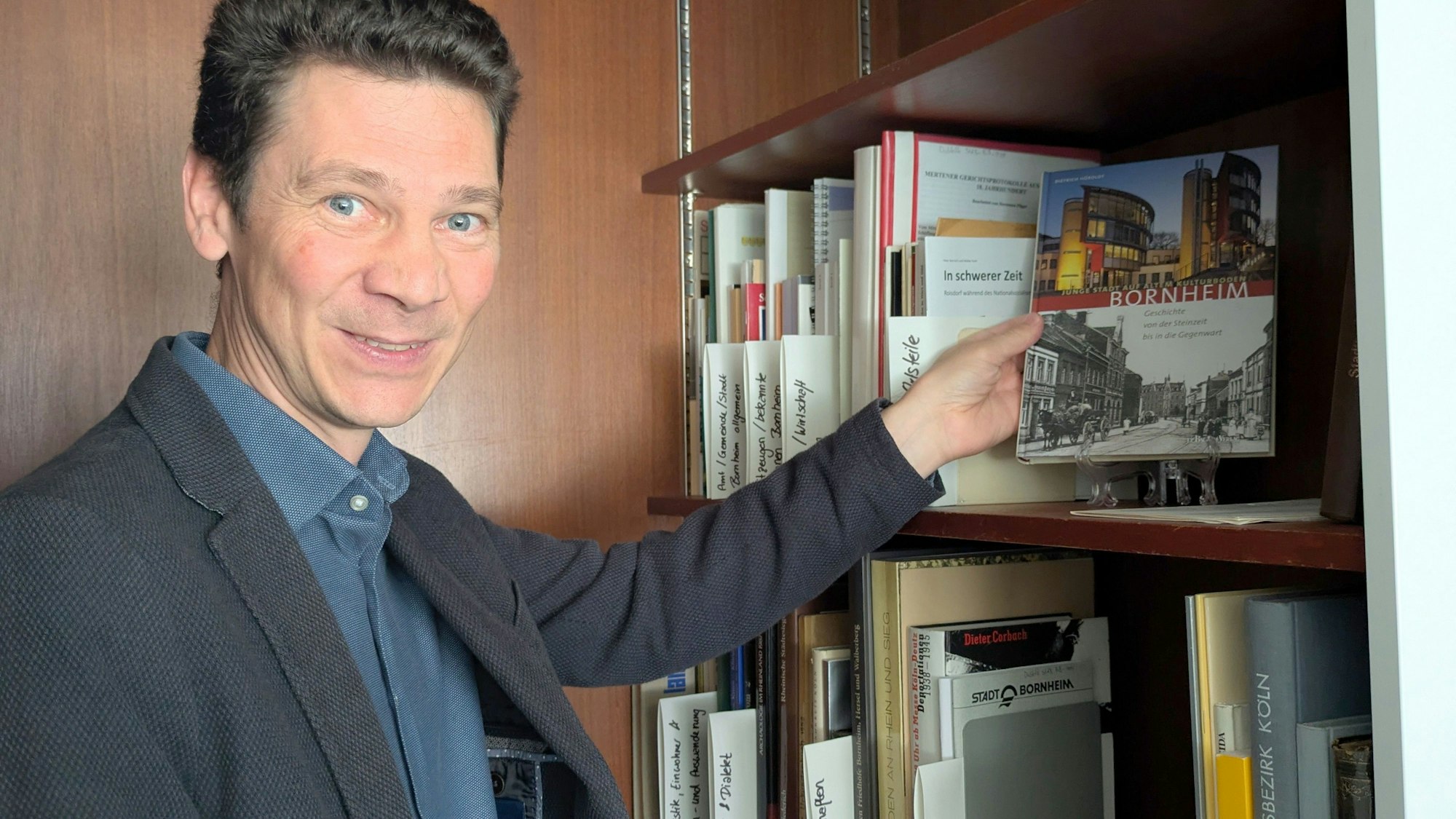 Stadtarchivar Dr. Simon Oelgemöller präsentiert eine Handbibliothek für den Nutzerraum.