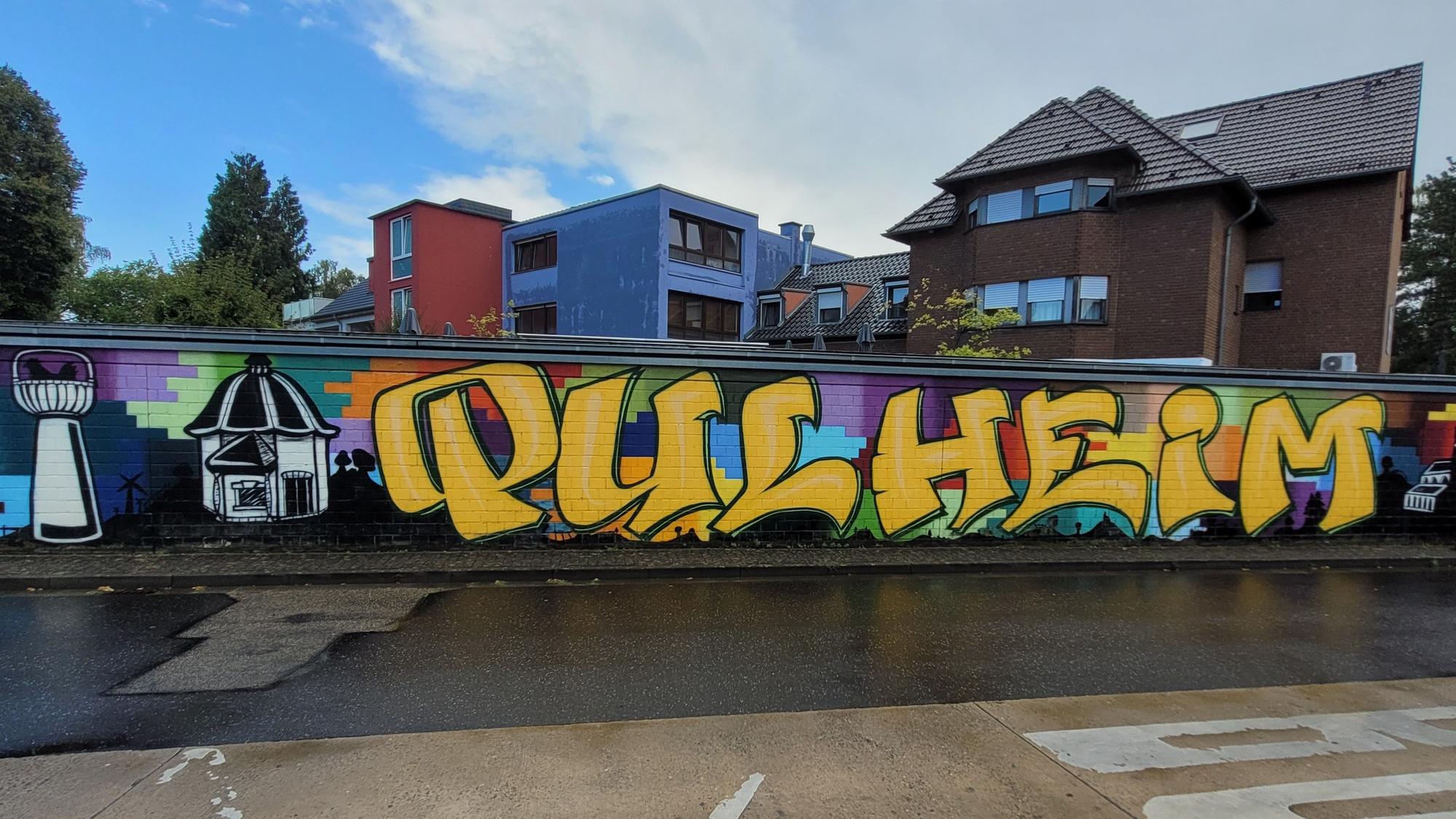 Ein buntes Graffito, unter anderem ist der Schriftzug „Pulheim“ zu sehen.