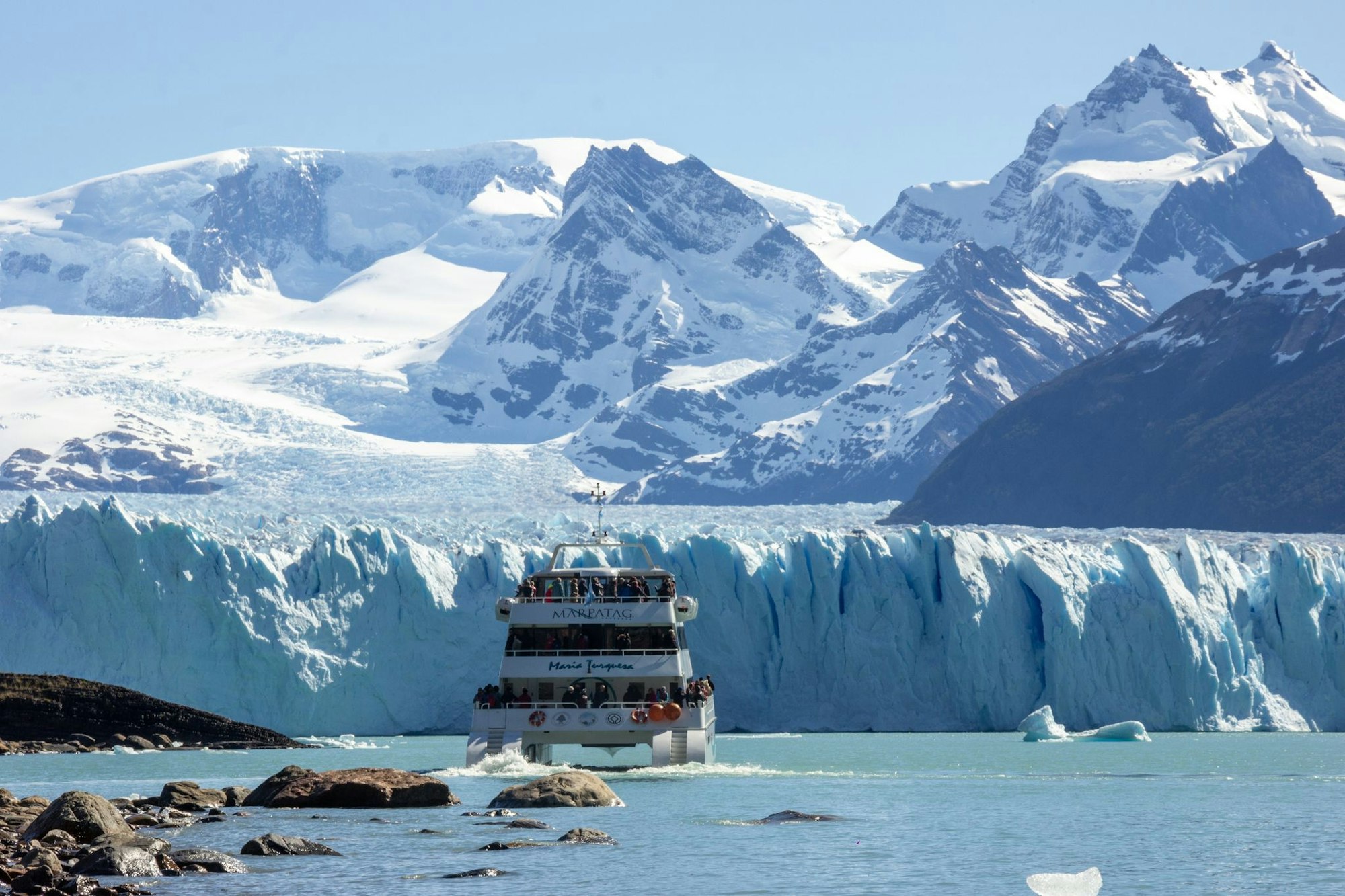 Touristen fahren durch den Lago Argentino an den Gletscher Perito Moreno.