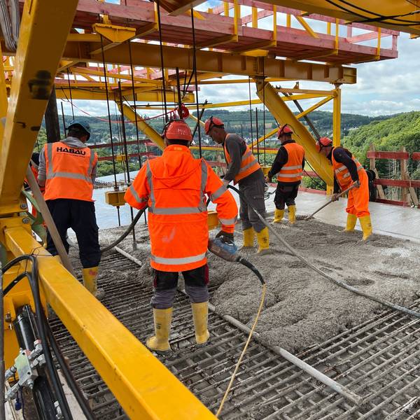 Arbeiter stehen auf der neu errichteten Rahmedetalbrücke bei Lüdenscheid.