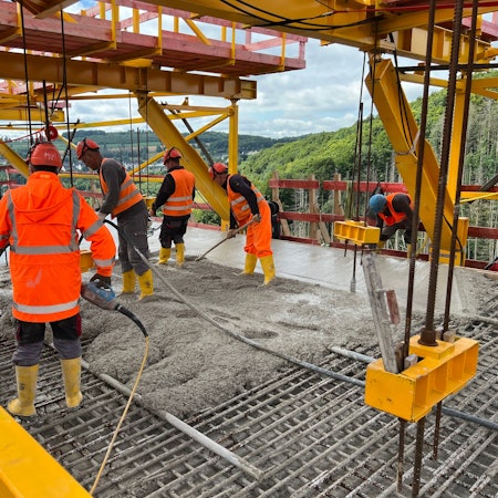 Arbeiter stehen auf der neu errichteten Rahmedetalbrücke bei Lüdenscheid.
