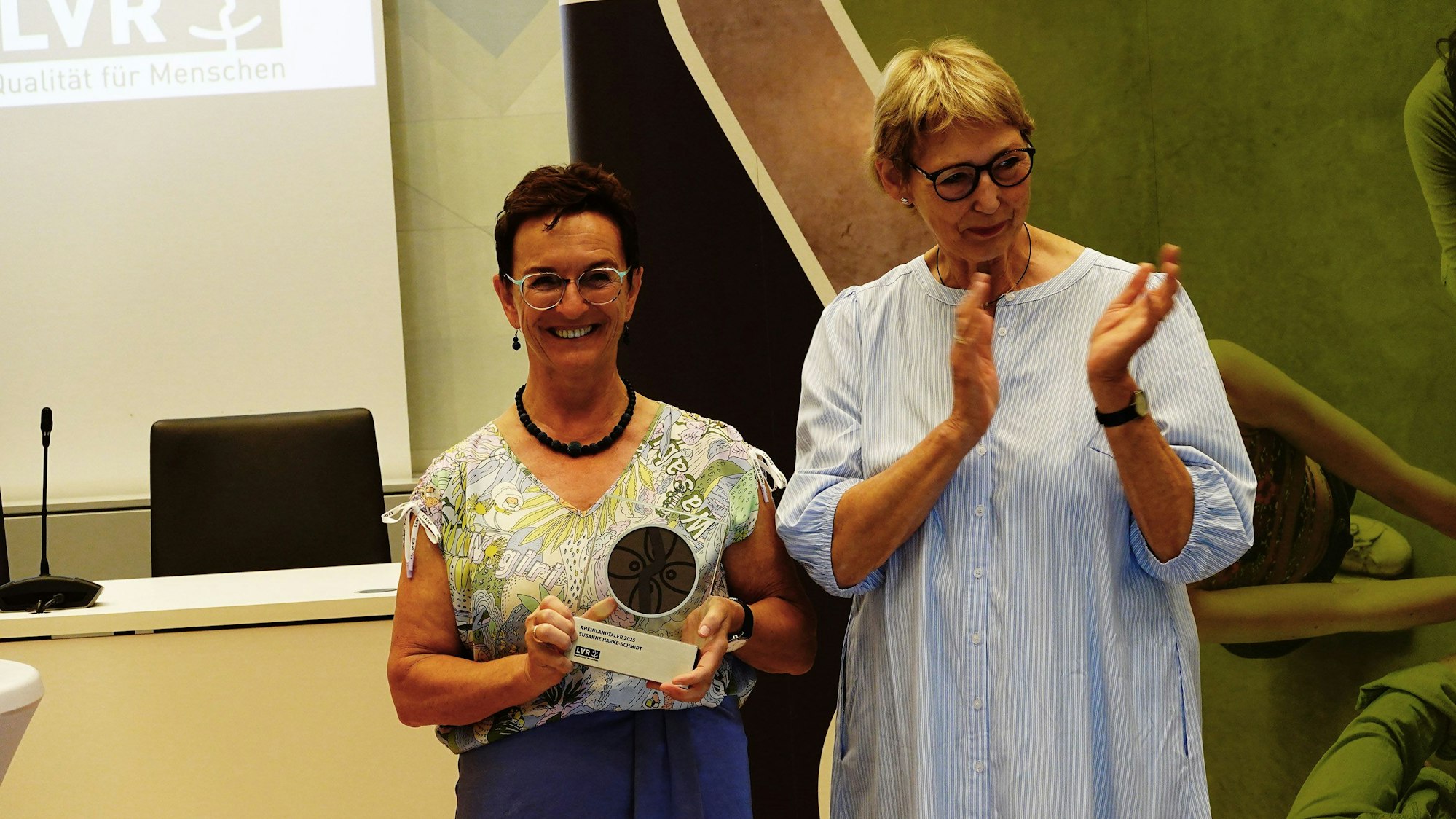 Das Foto zeigt zwei Frauen, davon eine mit einem Preis in der Hand.