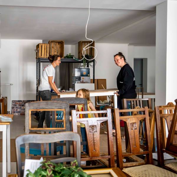 Das Bild zeigt Andrea Pick, die mit ihrer Frau Julia einen Tisch trägt.