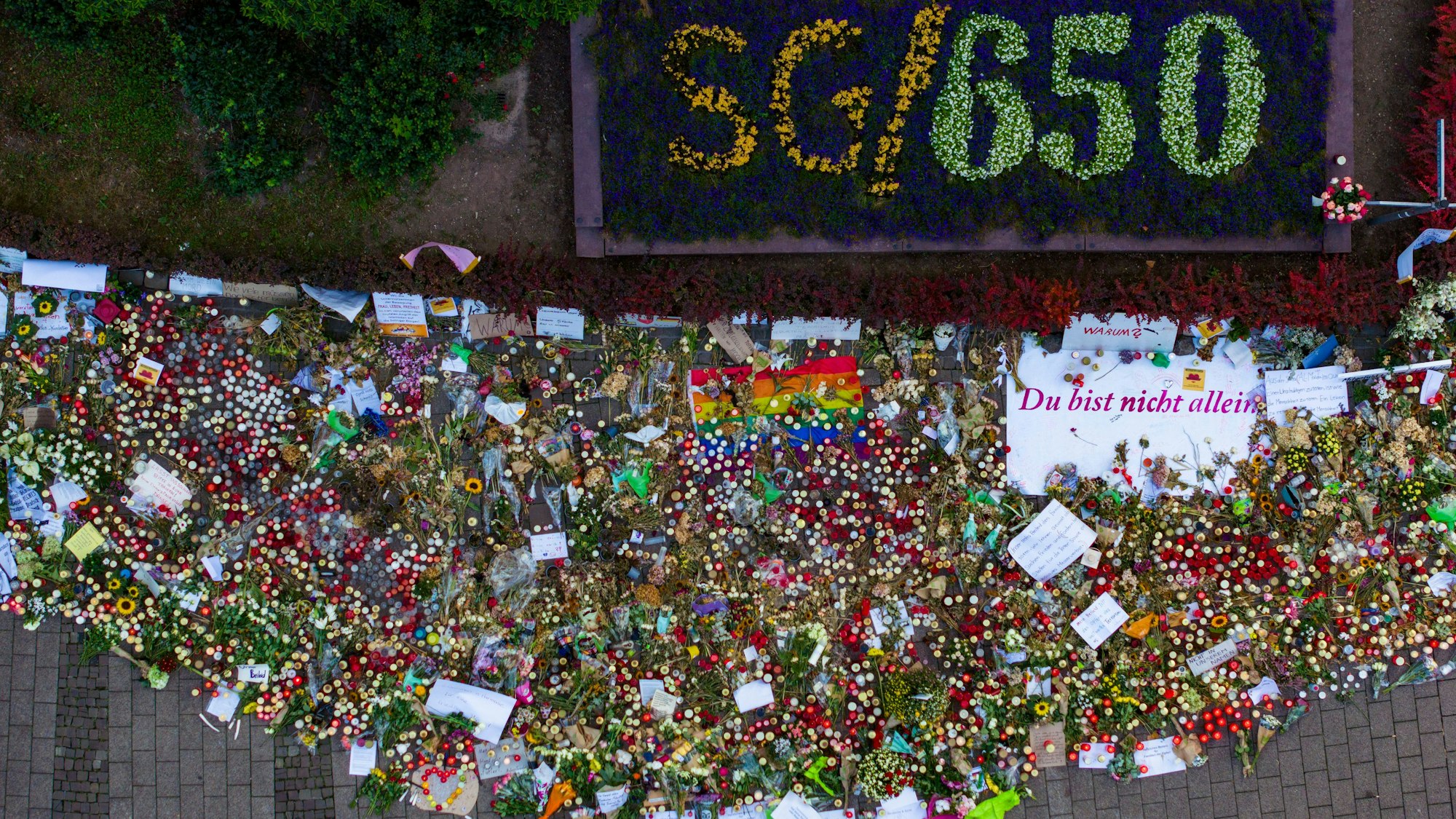 ARCHIV - 01.09.2024, Nordrhein-Westfalen, Solingen: Hunderte Kerzen, Blumen und Trauerschreiben am Gedenkort unweit des Tatorts. Bei einem mutmaßlich islamistischen Anschlag hatte ein Mann drei Besucher des Solinger Stadtfestes mit einem Messer getötet und zahlreiche weitere Menschen verletzt worden. (Luftbild mit einer Drohne) (zu dpa: «Gedenken an die Opfer des Solinger Anschlags») Foto: Christoph Reichwein/dpa +++ dpa-Bildfunk +++