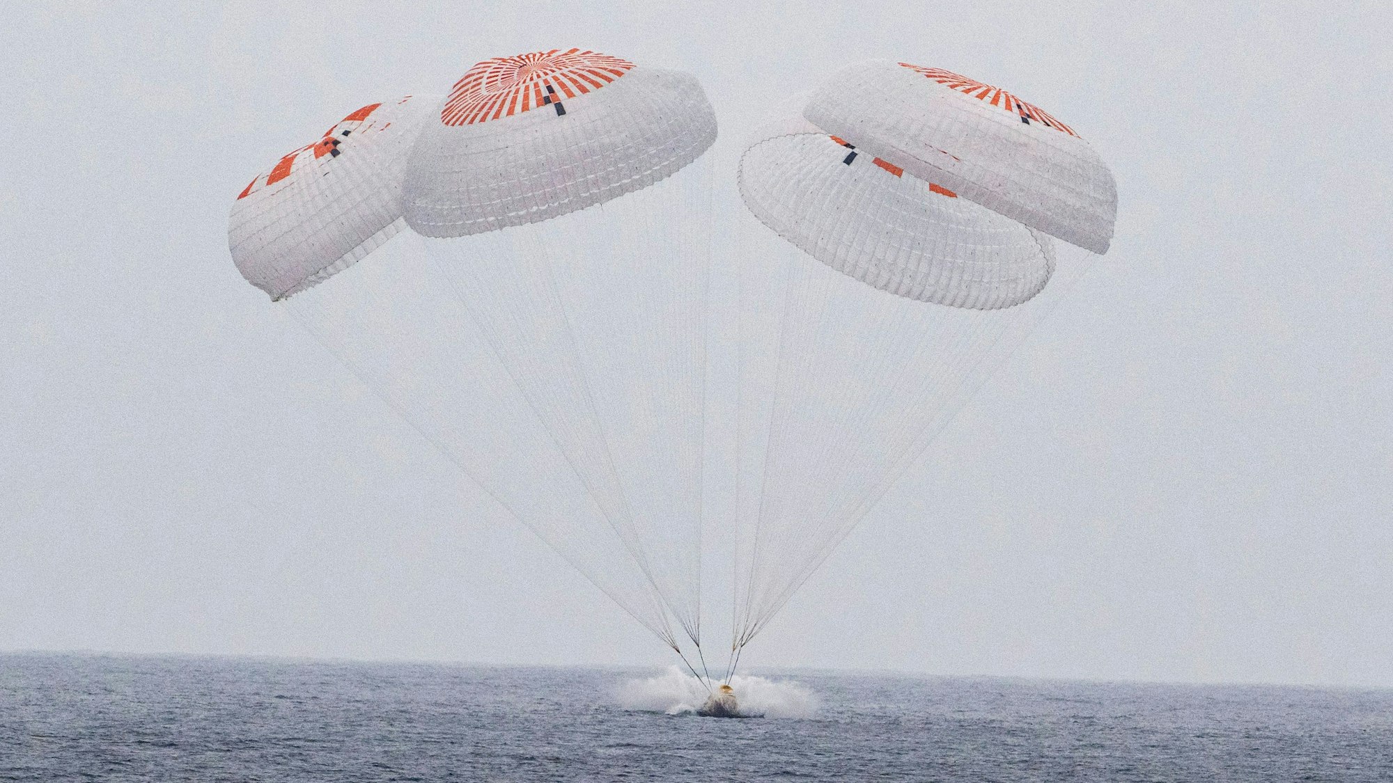 dpatopbilder - HANDOUT - 09.08.2025, USA, -: In diesem von der Nasa via AP zur Verfügung gestellten Bild gleitet die SpaceX-Kapsel mit vier Astronauten an Bord am Samstag vor der südkalifornischen Küste an Fallschirmen in den Pazifik. Nach rund fünf Monaten an Bord der Internationalen Raumstation sind vier Raumfahrer zurück auf der Erde. Mit einem «Crew-Dragon» des Raumfahrtunternehmens SpaceX von Tech-Milliardär Musk landete die «Crew 10» im Meer vor der Küste des US-Bundesstaates Kalifornien. Foto: Keegan Barber//Nasa/dpa - ACHTUNG: Nur zur redaktionellen Verwendung im Zusammenhang mit der aktuellen Berichterstattung und nur mit vollständiger Nennung des vorstehenden Credits +++ dpa-Bildfunk +++