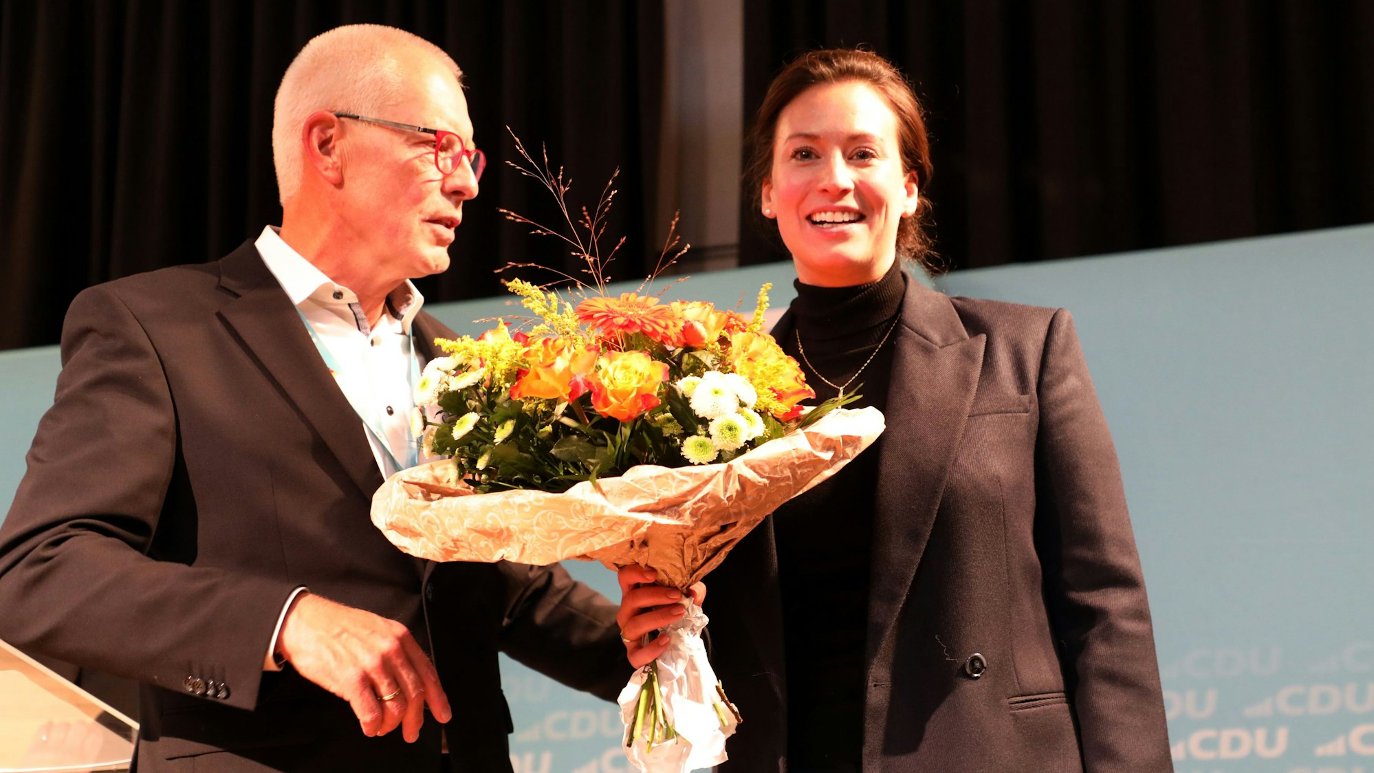 Caroline Bosbach hält einen Blumenstrauß von dem CDU-Kreisvorsitzenden Dr. Hermann-Josef Tebroke in Händen.