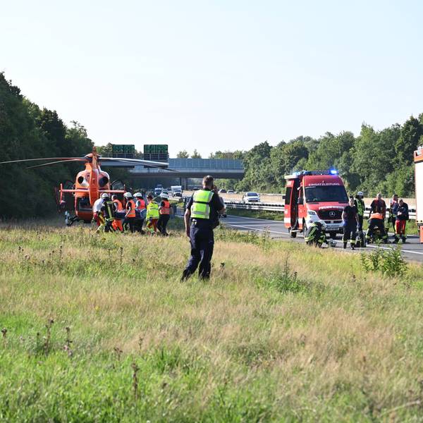 Das Bild zeigt Einsatzkräfte der Feuerwehr, die einen schwerverletzten Mann in den Rettungshubschrauber tragen.