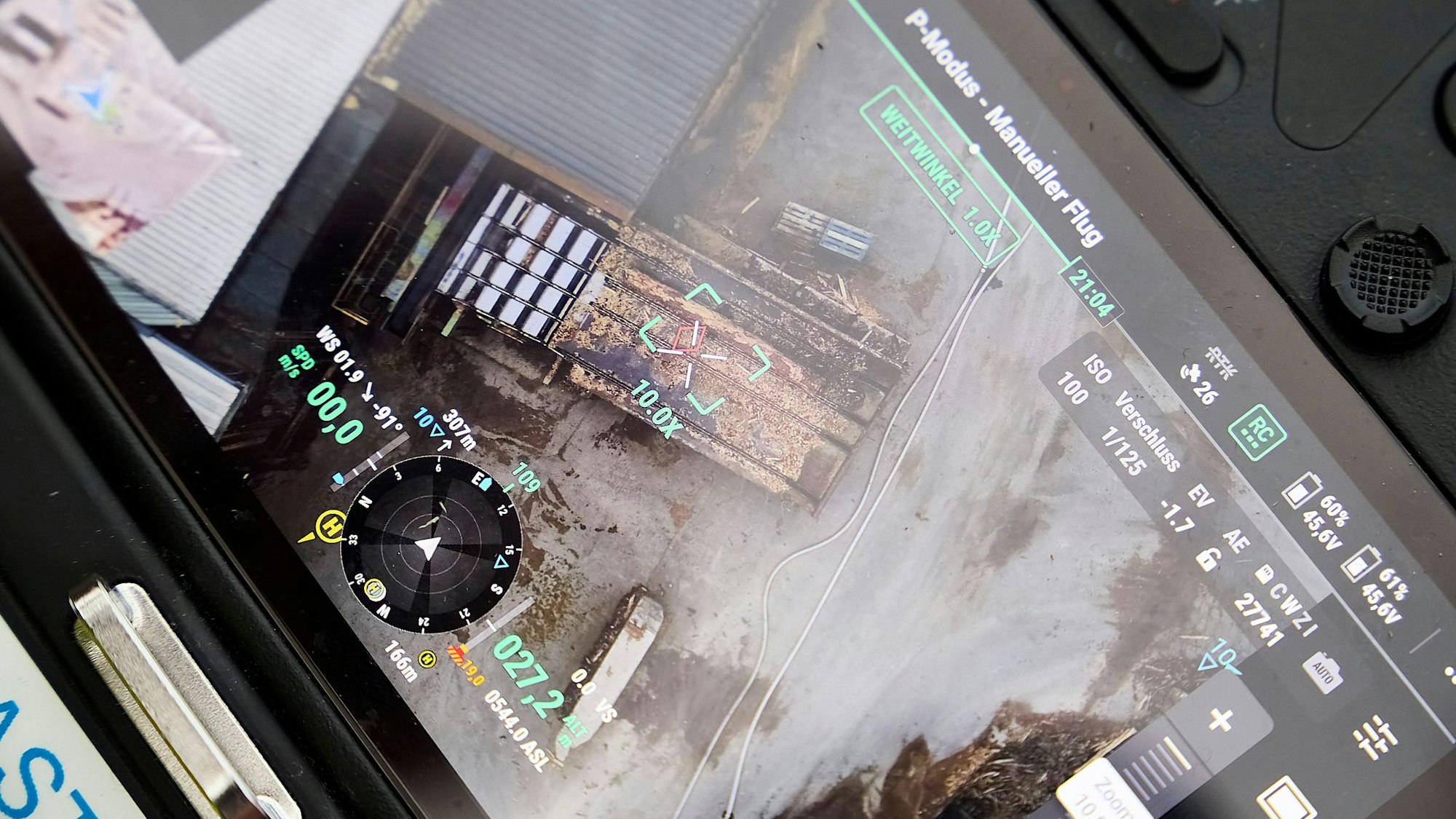 Gezeigt wird das ein von einer Drohne aufgenommenes Bild, das ein Förderband mit einem Baumstamm zeigt.