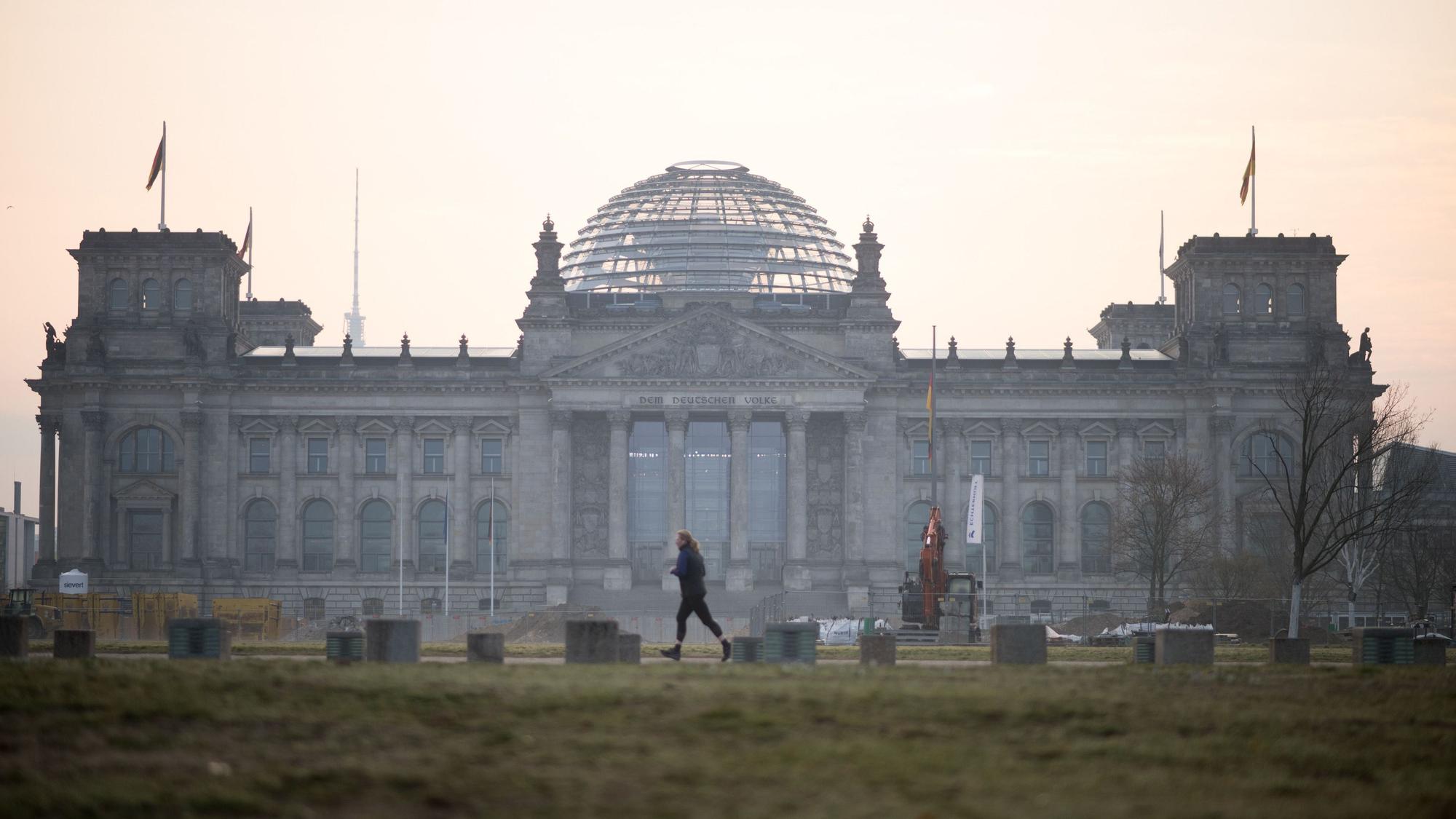 Eine Frau joggt am Tag der Konstituierenden Sitzung des 21. Deutschen Bundestages vordem Reichstag.