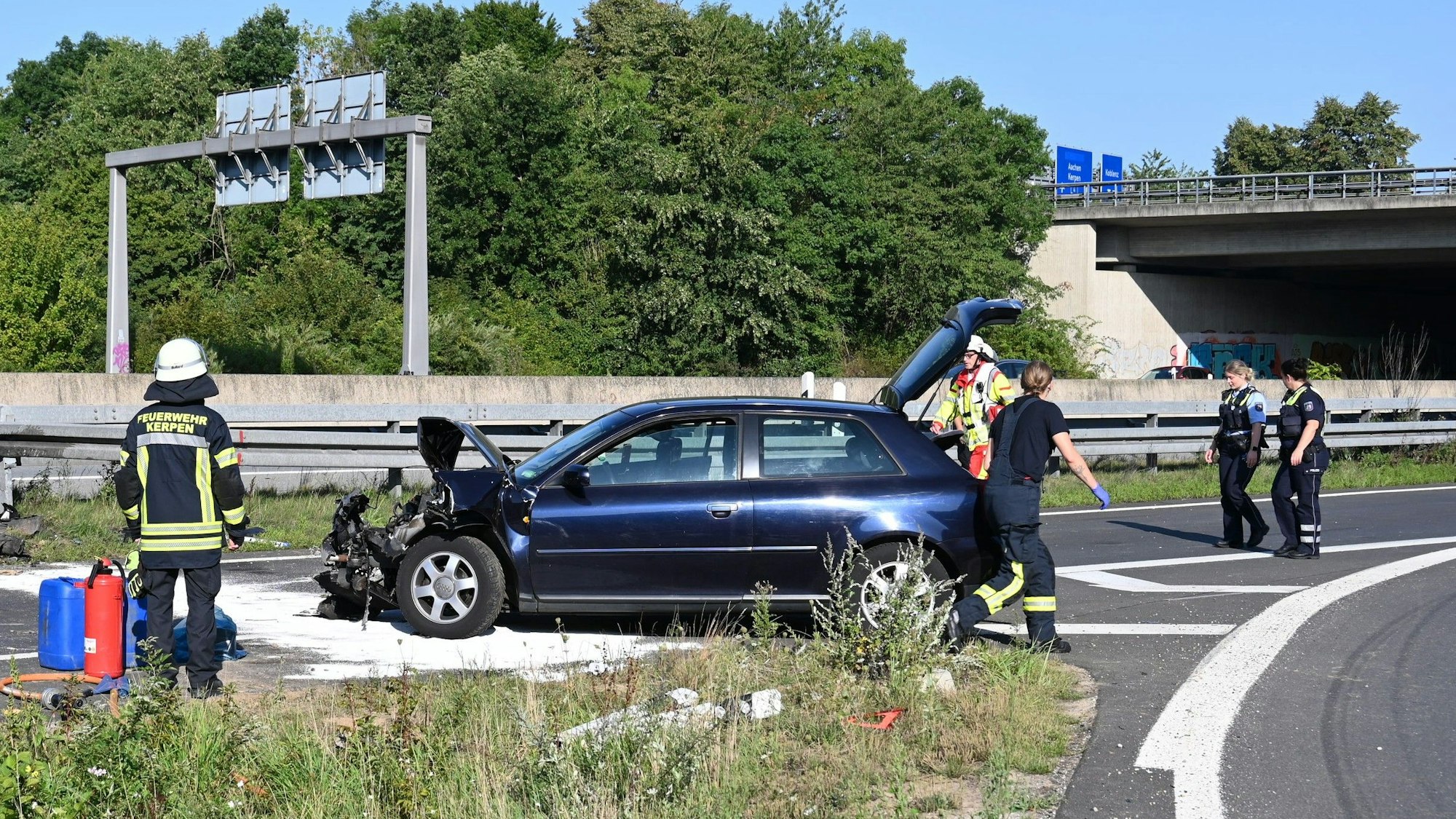 Das Bild zeigt Einsatzkräfte an einem beschädigten Auto auf der Autobahn