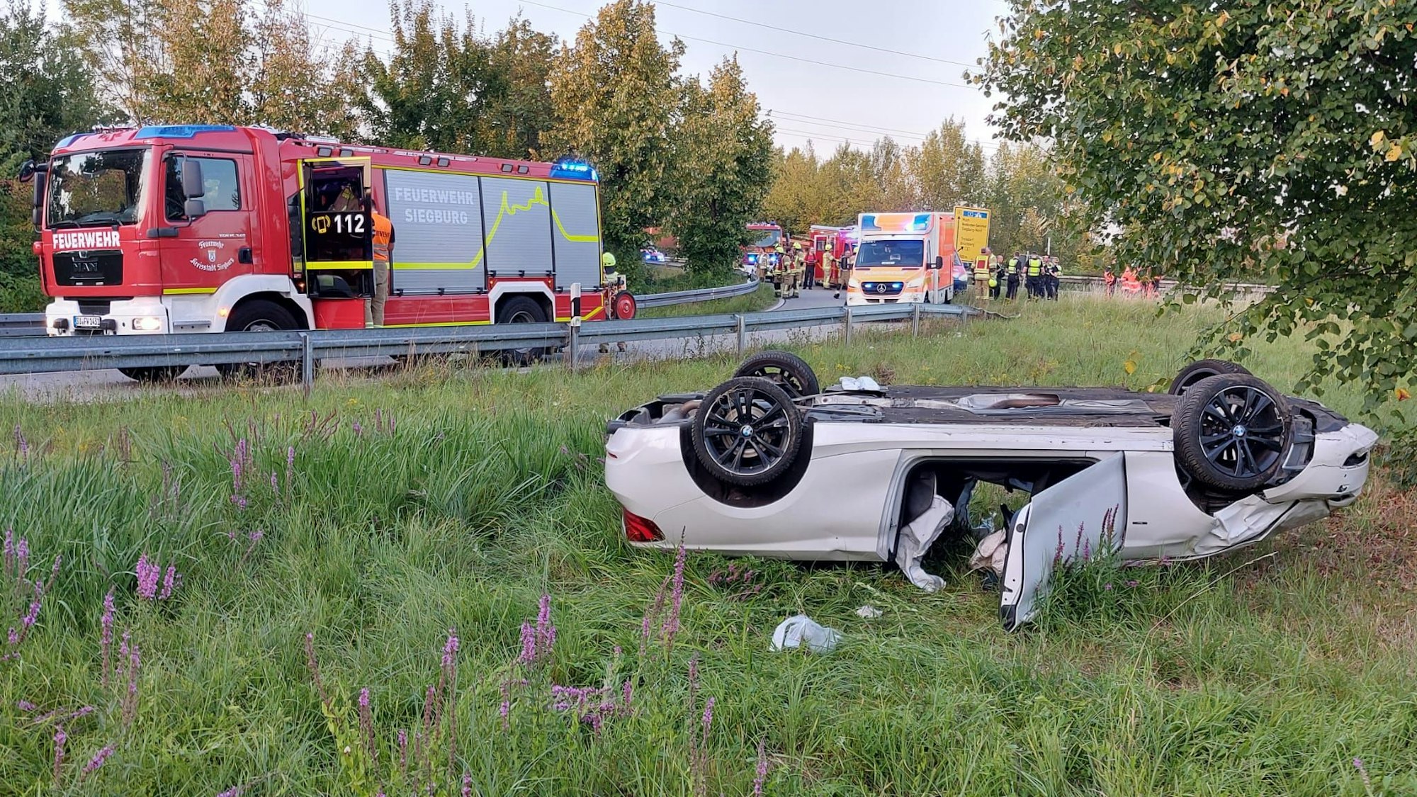 Ein weißes Cabrio liegt auf dem Dach.