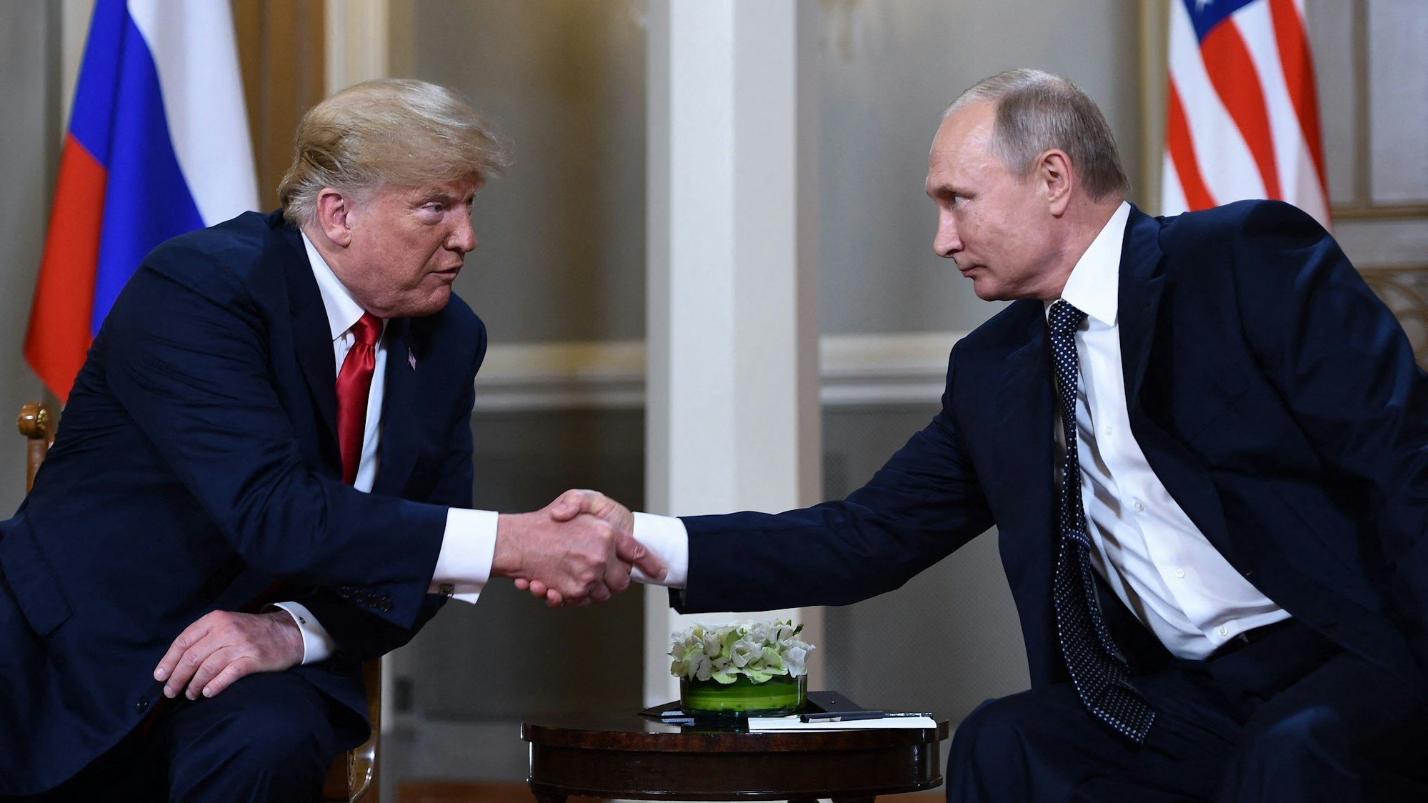 (FILES) Russian President Vladimir Putin (R) and US President Donald Trump shake hands before a meeting in Helsinki on July 16, 2018. US President Donald Trump said on August 8, 2025 he would meet with Russian counterpart Vladimir Putin on August 15 in Alaska, as the Republican billionaire hopes to help mediate an end to the war in Ukraine. (Photo by Brendan Smialowski / AFP)