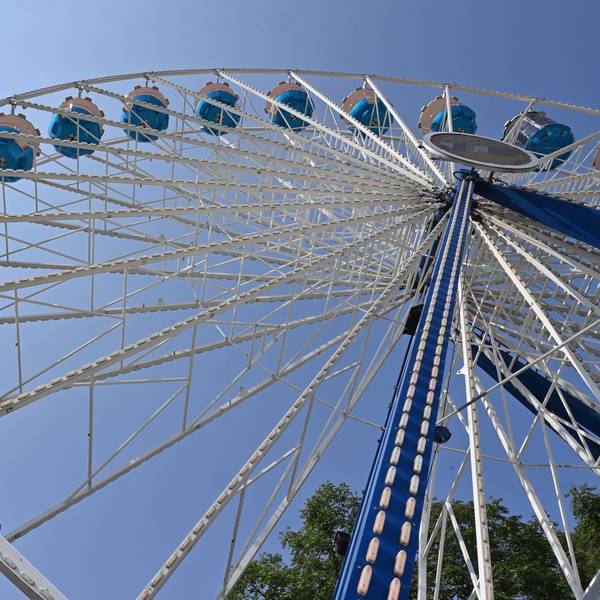 Ein Riesenrad vor blauem Himmel.