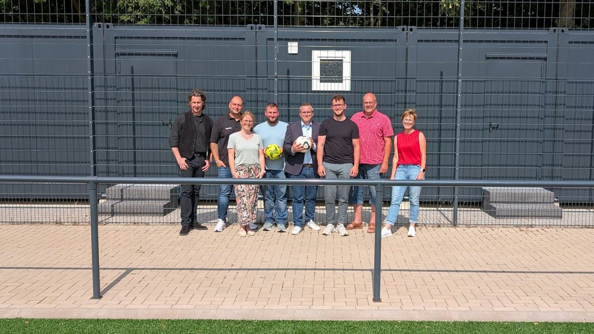 Mehrere Menschen stehen vor Umkleidecontainern.