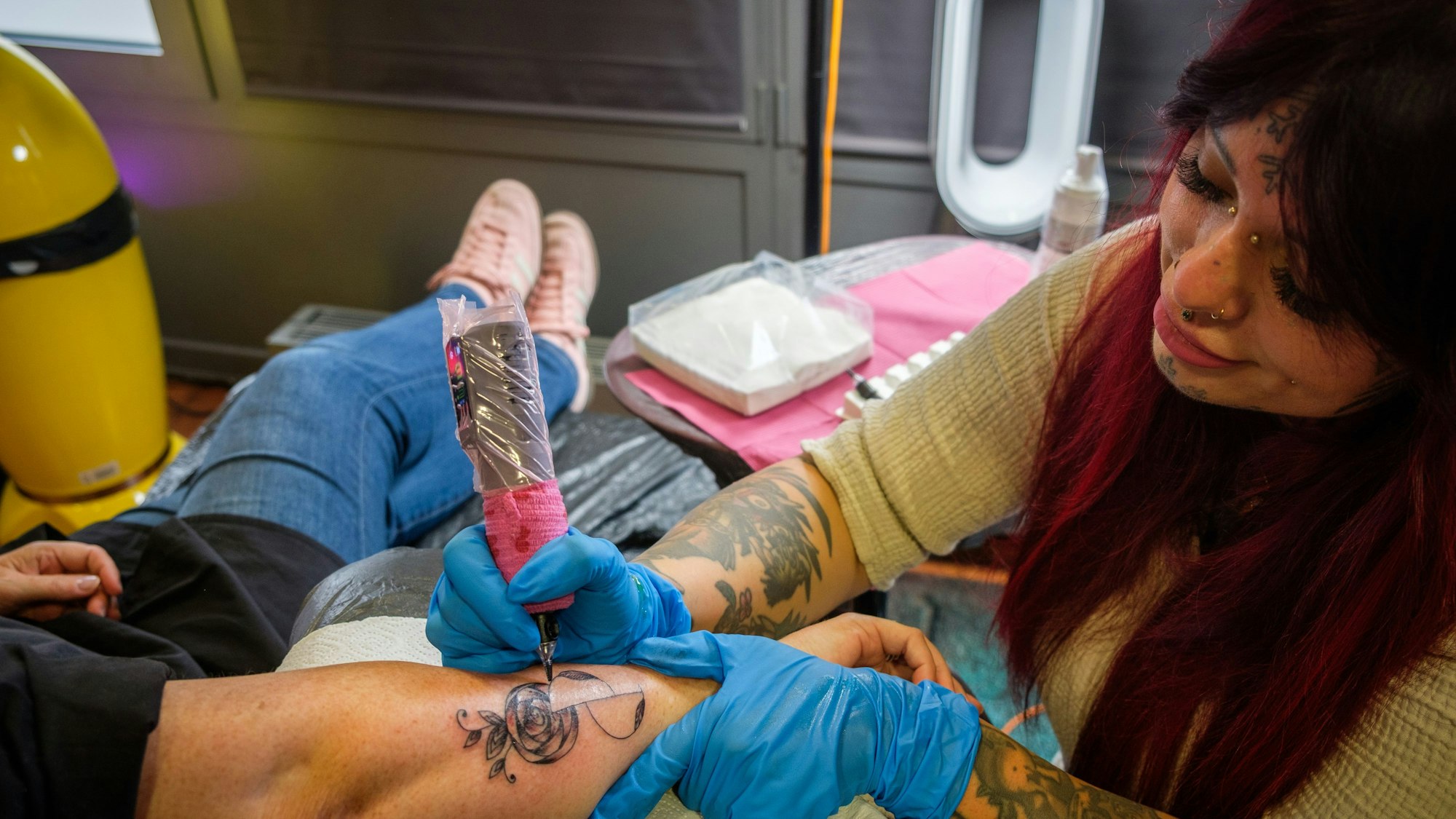 Eine Frau sticht ein Tattoo.