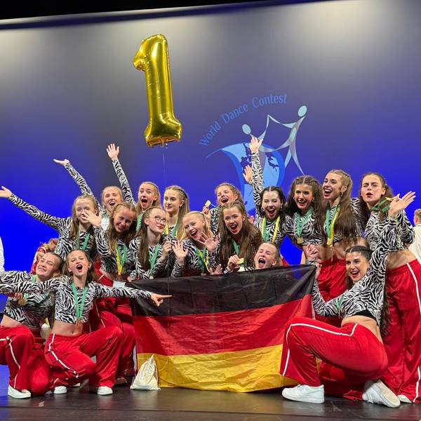Das Foto zeigt die Tanzgruppe beim Jubeln mit einer Deutschlandfahne.