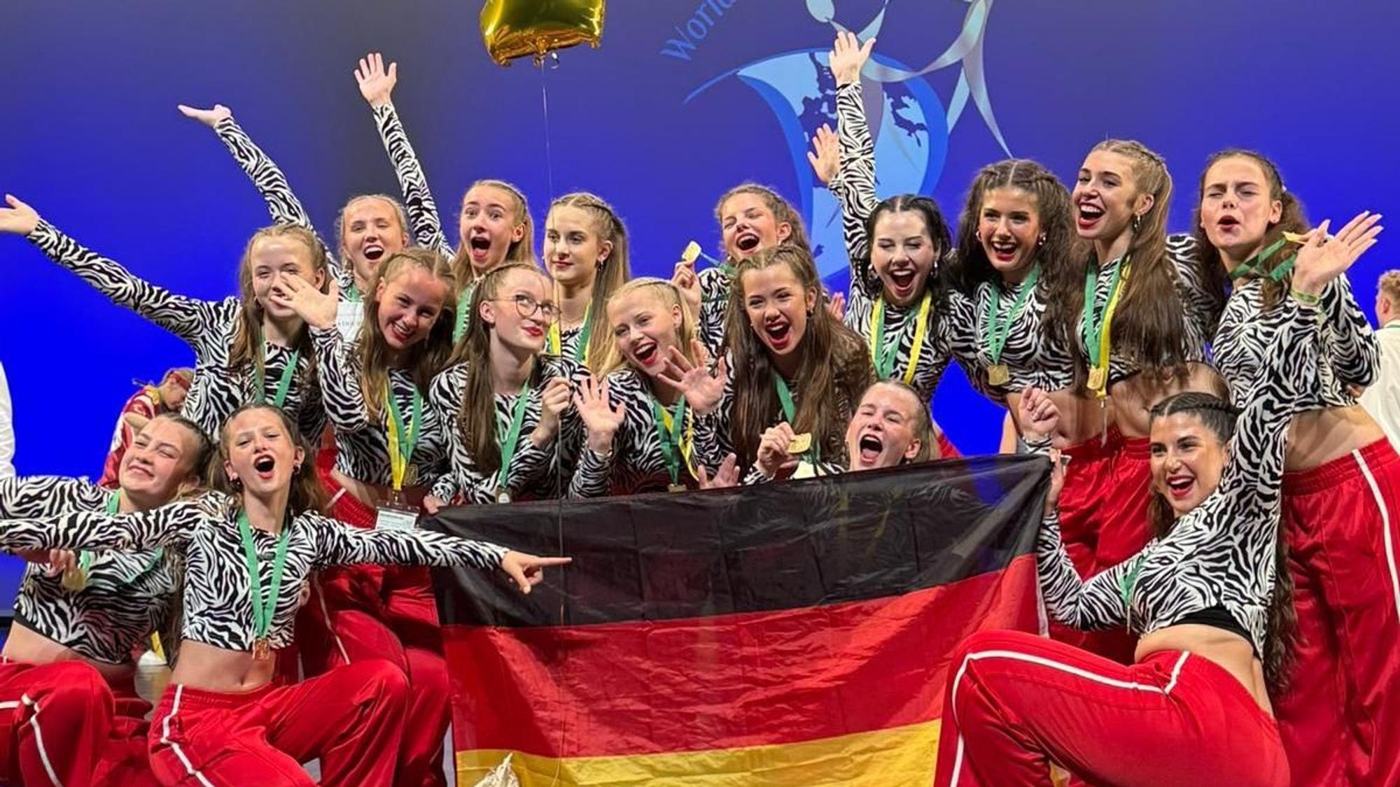 Das Foto zeigt die Tanzgruppe beim Jubeln mit einer Deutschlandfahne.